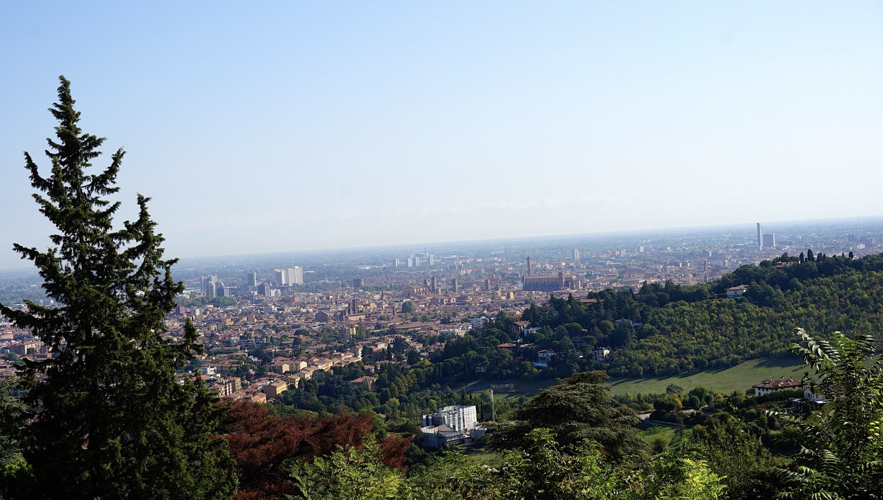 Panoramablick vom Hügel über Bologna und umliegende Grünflächen.