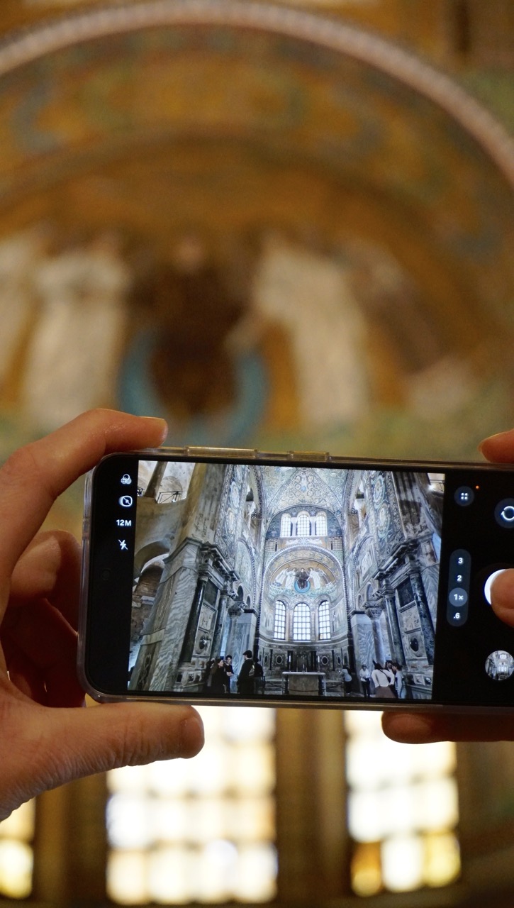Handy fotografiert reich geschmücktes Kircheninnere; Fokus aufs Display.