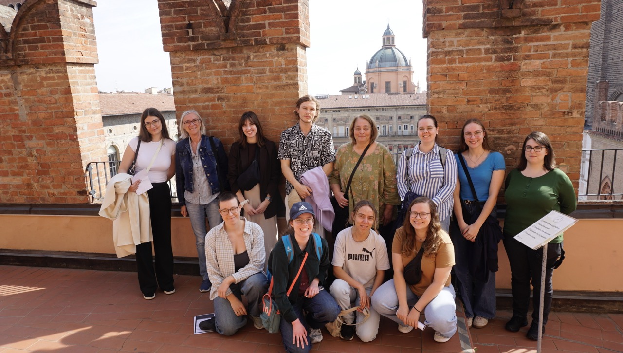 Gruppenfoto auf Terrasse; Kuppel und Altstadt von Bologna im Hintergrund.